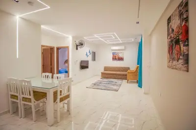 a dining room and living room with a table and chairs at La Prestigia in Hurghada