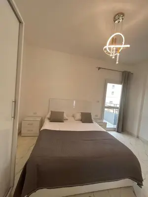 a bedroom with a large bed and a chandelier at La Prestigia in Hurghada