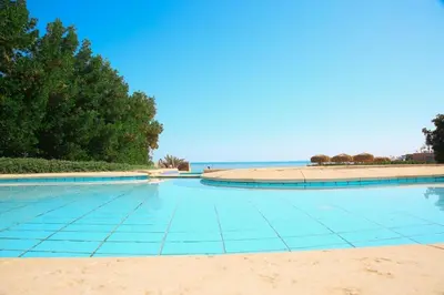 a swimming pool with a beach in the background at White villa phase2 - Elgouna 5BD in Hurghada