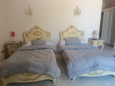 two beds sitting next to each other in a bedroom at White villa phase2 - Elgouna 5BD in Hurghada
