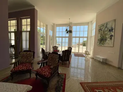 a living room with chairs and a table and windows at White villa phase2 - Elgouna 5BD in Hurghada