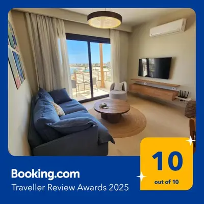 a living room with a blue couch and a tv at Sunrise to Sunset Rooftop Panorama - El Gouna Shedwan in Hurghada