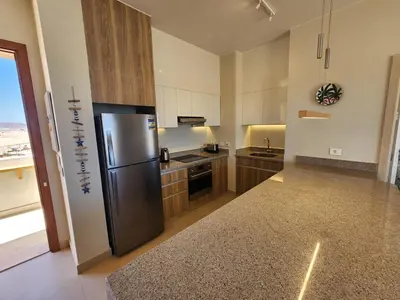 a kitchen with a stainless steel refrigerator in a room at Sunrise to Sunset Rooftop Panorama - El Gouna Shedwan in Hurghada