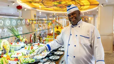 a chef standing in a kitchen preparing food at Orient Grand Rose Nile Cruise - Every Saturday from Luxor for 07 & 04 Nights - Every Wednesday From Aswan for 03 Nights in Luxor