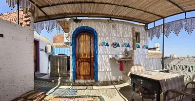 a small house with a wooden door on a balcony at Lale Hoste in Nag` el-Ramla