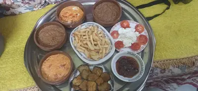 a plate with different types of food on a table at Lale Hoste in Nag` el-Ramla
