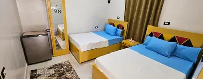 a small bedroom with two beds and a mirror at Lale Hoste in Nag` el-Ramla