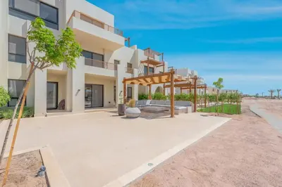 a house on the beach with a patio at Tranquil 2BR in Shedwan I El Gouna I Pool and Lagoon View in Hurghada