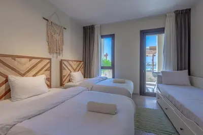 a hotel room with three beds and a window at Tranquil 2BR in Shedwan I El Gouna I Pool and Lagoon View in Hurghada
