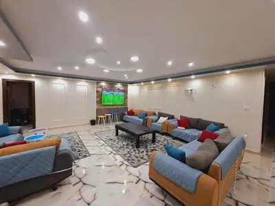 a large living room with couches and a flat screen tv at Nile Bride in Naj‘ al ‘Amrāb