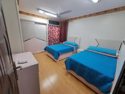 a small room with two beds and a closet at Nile Bride in Naj‘ al ‘Amrāb