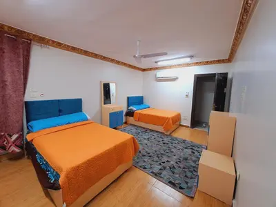a bedroom with two beds and a rug at Nile Bride in Naj‘ al ‘Amrāb