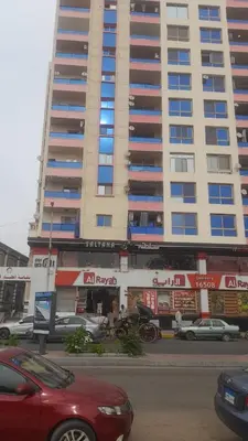 a large building with cars parked in front of it at Nile Bride in Naj‘ al ‘Amrāb