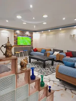 a living room with couches and a flat screen tv at Nile Bride in Naj‘ al ‘Amrāb