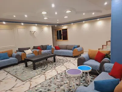 a living room with couches and tables in a room at Nile Bride in Naj‘ al ‘Amrāb