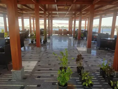 a room with tables and chairs and potted plants at Nuba Nile Hotel in Aswan