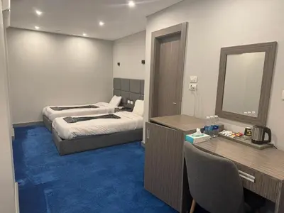 a bedroom with a bed and a desk and a mirror at Nuba Nile Hotel in Aswan