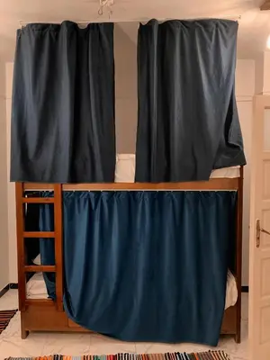 a bunk bed with black curtains on it at MRHostel Luxor in Luxor