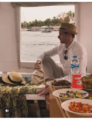 a man sitting on a boat with plates of food at Aswan in Aswan