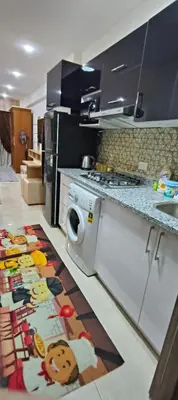 a kitchen with a washing machine on the floor at Tiba Golden Resort Studio in Hurghada