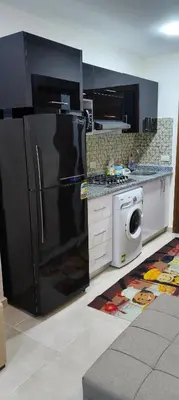 a kitchen with a black refrigerator and a dishwasher at Tiba Golden Resort Studio in Hurghada