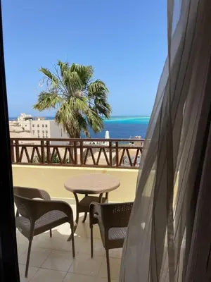 a balcony with a table and chairs and the ocean at Studil for rent 206 hill in Hurghada