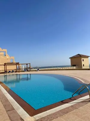 a large blue swimming pool next to a building at Studil for rent 206 hill in Hurghada