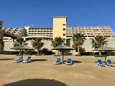 a group of chairs and umbrellas in front of a building at Studil for rent 206 hill in Hurghada