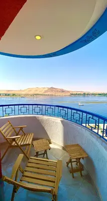 a group of chairs and tables on a building with a view of the water at aswan view 3 bedrooms in Aswan
