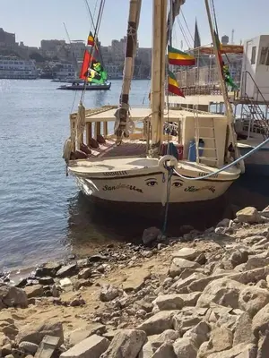 a boat sitting on the shore of the water at Sailing spirit in Aswan