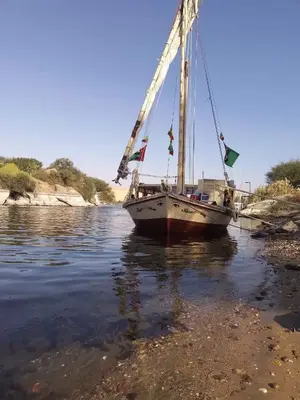 a boat sitting in the water next to the shore at Sailing spirit in Aswan
