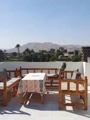 a patio with a table and chairs on a roof at Sekhmet Appartement sur le roof in Luxor
