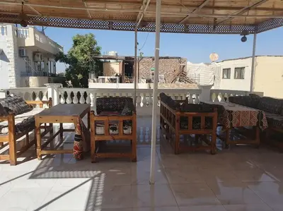 a patio with tables and chairs on a roof at Sekhmet Appartement sur le roof in Luxor
