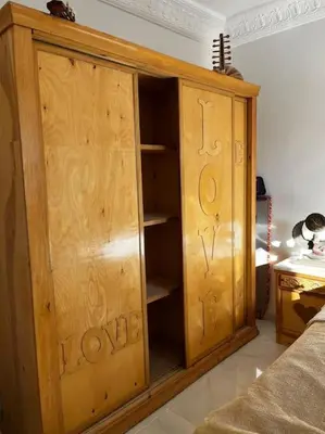 a wooden cabinet with the words love written on it at Sekhmet Appartement sur le roof in Luxor