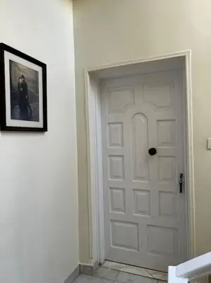 a white door in a room with a picture on the wall at Sekhmet Appartement 2 chambres in Luxor