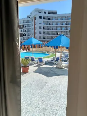 a view of a pool with chairs and umbrellas at Tiba Golden Resort apartment 45 with beach access in Hurghada