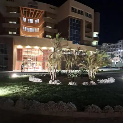 a building with palm trees in front of it at night at Tiba Golden Resort apartment 45 with beach access in Hurghada