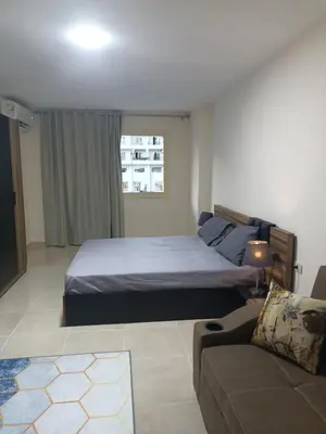 a bedroom with a bed and a couch at Tiba Golden Resort apartment 45 with beach access in Hurghada