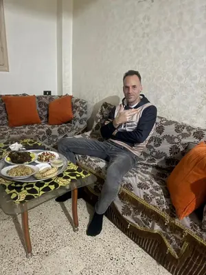a man sitting on a couch with a table at SEO House in Aswan