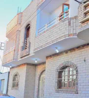 a brick building with a balcony on top of it at king valley House in ‘Ezbet Abu Ḥabashi
