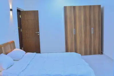 a bedroom with a bed and two wooden doors at king valley House in ‘Ezbet Abu Ḥabashi