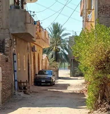 a car parked in a street next to buildings at king valley House in ‘Ezbet Abu Ḥabashi