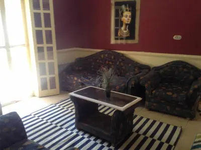 a living room with a couch and a table at Luxor Stables Apartment in Luxor