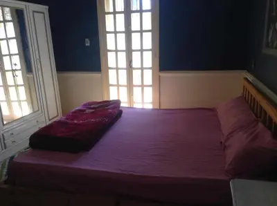 a bed in a room with a purple blanket on it at Luxor Stables Apartment in Luxor
