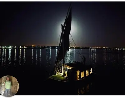 a boat sitting in the water at night at faloka Farha Camp in Aswan