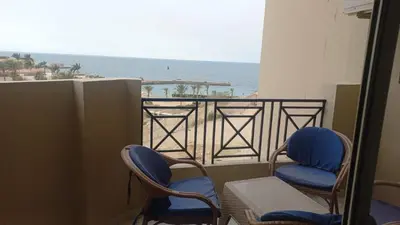a balcony with two chairs and a view of the ocean at Juliana Beach Resort in Hurghada