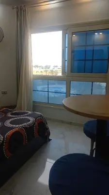 a bedroom with a bed and a table and a window at Juliana Beach Resort in Hurghada