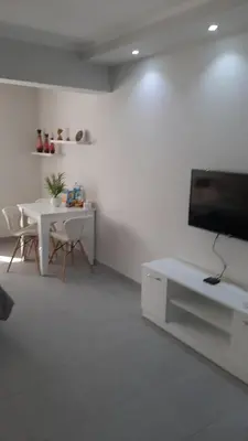 a living room with a flat screen tv and a table at Hurghada Ägypten Scandic Resort in Hurghada