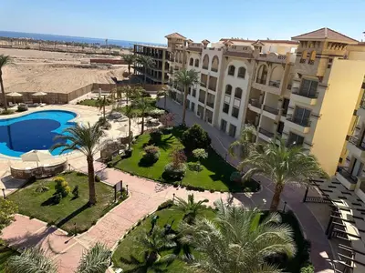 an aerial view of a resort with a pool and palm trees at Fully equipped studio Sahl Hasheesh in Hurghada