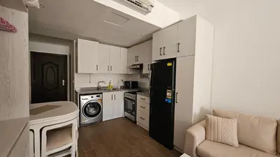 a kitchen with a black refrigerator and a washer at Fully equipped studio Sahl Hasheesh in Hurghada